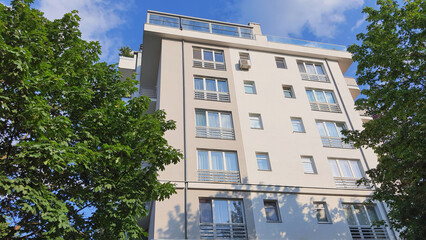 Modern residential building surrounded by greenery on a sunny day in an urban area