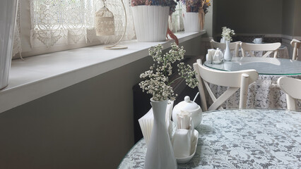 Cozy cafe setting with vintage decor and delicate floral arrangements in a sunlit room