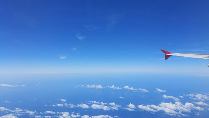 Sky view from an airplane wing above the ocean on a clear day