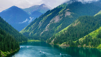 Weekend on Lake Kolsai in Kazakhstan. A mountain range covered with coniferous forests with an amazing natural reservoir