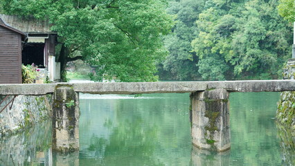 One old traditional Chinese village view with the old arched stone bridge and old wooden buildings...
