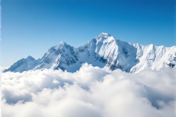 Obraz premium Majestic snow-capped mountains above the clouds under a clear blue sky.