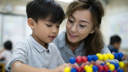 Obraz premium Teacher guiding young boy with colorful science model in classroom learning activity