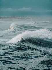 Dramatic ocean waves against a moody sky.