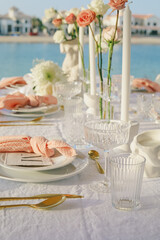 Outdoor wedding reception table with elegant floral arrangements.