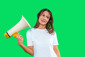 Woman holding megaphone against bright green background while looking to the side, displaying confidence and enthusiasm in an expressive manner