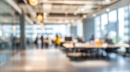 Blurred office interior with desks chairs and people working in the background.