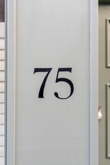 Black painted number seventy five by doorway