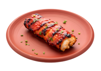 A flavorful, grilled, and glazed meat dish rests attractively on a terracotta plate, showcasing a rich red sauce and garnished with fresh herbs.