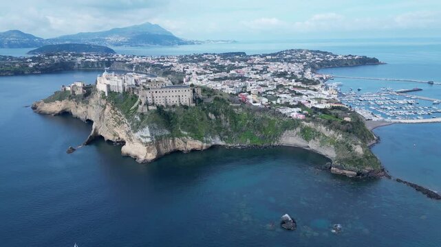 Panoramic drone flight towards rugged coastline and historic buildings on Terra Murata hill, tourism and landscapes Procida Italy