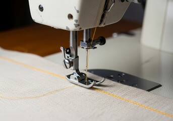 Close-up of sewing machine stitching fabric with yellow thread, textile project in progress.