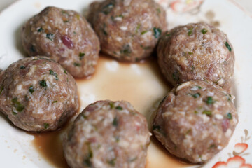 Homemade meatballs prepared with fresh herbs and spices ready for cooking in a traditional style