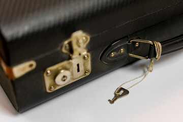 Black leather briefcase with gold lock and zipper detail on a clean background