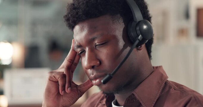 Headset, headache and tired call center consultant in office with crm, contact us or communication. Mic, burnout and male technical support agent with consulting for customer experience in workplace.