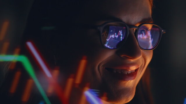 Late trader studying graphs wearing glasses watching laptop display closeup