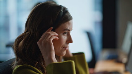 Woman receptionist wear headset looking computer in helpdesk office closeup