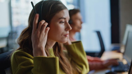 Closeup hand grabbing headset communication at workplace. Specialist assisting