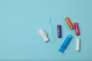 feminine pads, tampons, menstrual cup feminine hygiene products on a blue background
