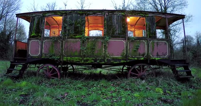 Old abandoned caravan in a field at dusk.