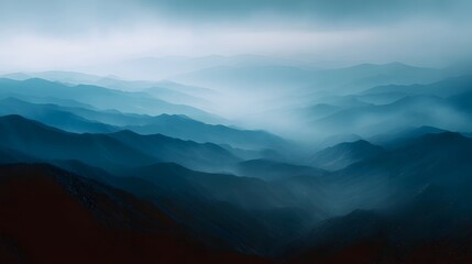 Fototapeta premium Layered blue mountain ridges shrouded in atmospheric mist and haze create a serene vast and epic landscape vista