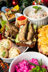 Traditional Eastern European holiday table with smoked fish sandwiches, beet salad, caviar tartlets, seafood appetizers, and festive decorations