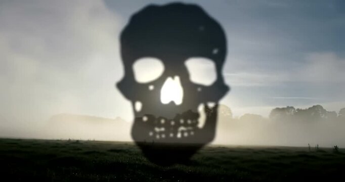 Silhouette of a skull against a cloudy sky.