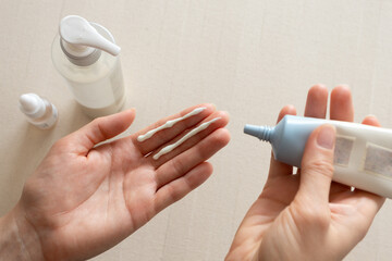 Facial sunscreen moisturizing cream on woman hand. Minimal and clean daily skincare and self-care routine. Concepts of beauty, dermatology, personal hygiene, natural cosmetics, and wellness lifestyle