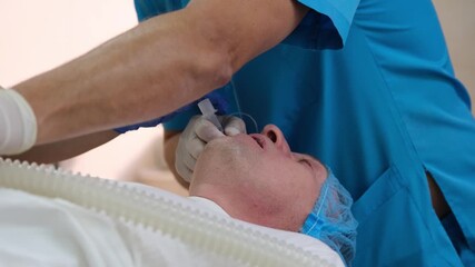 Surgeons and nurses are preparing and inserting an endotracheal tube into a patient's trachea to ensure proper ventilation during a surgical procedure inside a hospital operating room - Powered by Adobe