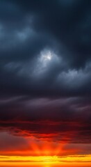 Obraz premium Dramatic Sunset Sky: Fiery Colors Beneath Dark, Stormy Clouds.