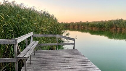 Obraz premium Wooden pier near reed thickets on a lake