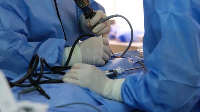 Medical professionals in sterile surgical attire meticulously perform a laparoscopic procedure, employing advanced instruments and techniques within a controlled operating room environment