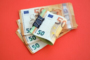 Big amount of european euro currency money notes on red color table close up
