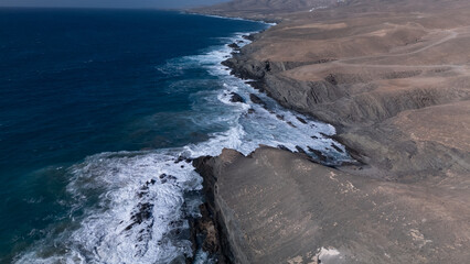 Fototapeta premium This is a high-angle aerial view of a coastline, showing the striking contrast between the ocean and the land.