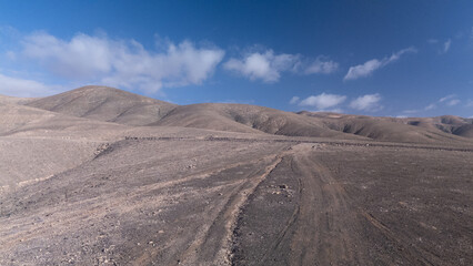 `Desert Track Through Volcanic Hills Under Clear Sky – Remote Arid Landscape