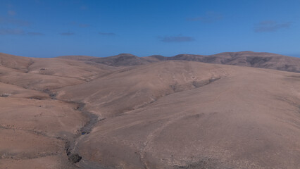 Desert Track Through Volcanic Hills Under Clear Sky – Remote Arid Landscape