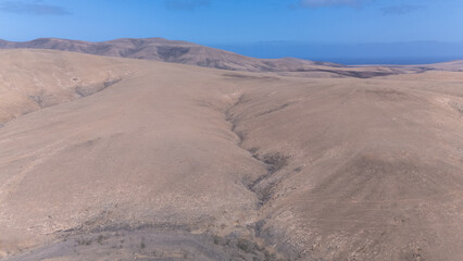 Desert Track Through Volcanic Hills Under Clear Sky &ndash; Remote Arid Landscape