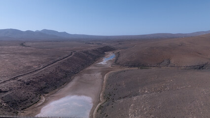 Aerial View of Desert Reservoir and Dam Structure in Arid Mountainous Landscape