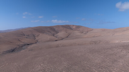 Desert Track Through Volcanic Hills Under Clear Sky – Remote Arid Landscape