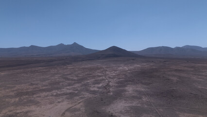 Desert Track Through Volcanic Hills Under Clear Sky – Remote Arid Landscape