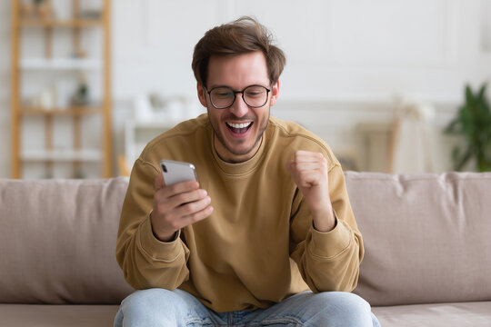 Excitement fills the room as young man celebrates good news while checking his smartphone in a cozy living area Generative AI