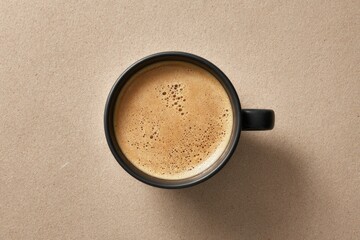 Minimalist top down view of a black coffee cup with fresh crema on a neutral background.