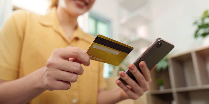 Cyber Monday shopping. Woman using smartphone and credit card for online purchases.