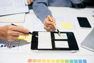 Creative UX UI team designing website wireframes, templates, and color systems with digital tools and real people in a tech office environment.