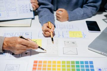 Creative UX UI team designing website wireframes, templates, and color systems with digital tools and real people in a tech office environment.