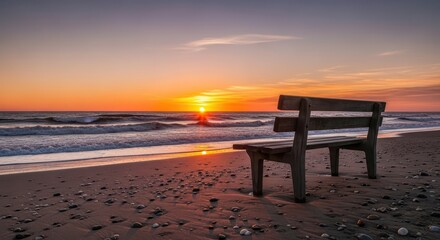 Solitary wooden bench on a pebble beach facing a vibrant ocean sunset