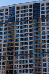 Exterior of a tall residential building in the City shows numerous windows, small balconies, and multiple air conditioning units attached to the facade