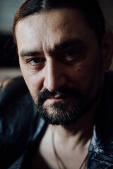 portrait of a handsome man with dark hair and a black beard