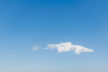 Single white cloud in clear blue sky