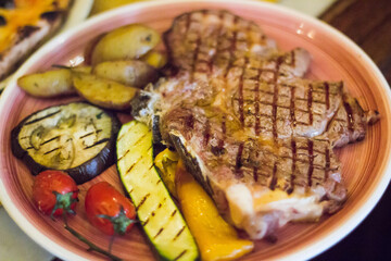 Grilled meat with roasted potatoes, zucchini, eggplant and cherry tomatoes