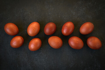 Easter Eggs Dyed with Onion Skins in a Row on Dark Surface